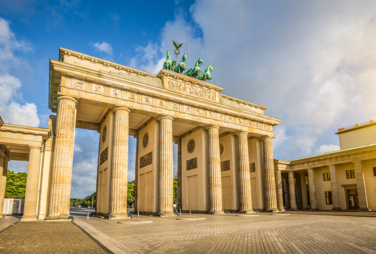 Famous Brandenburger Tor (Brandenburg Gate), one of the best-known landmarks and national symbols of Germany, in beautiful golden morning light at sunrise with lens flare effect, Berlin, Germany.
